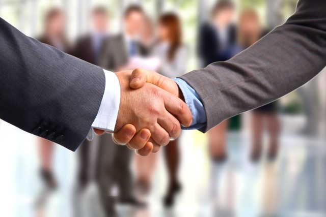 a close up of two people shaking hands.